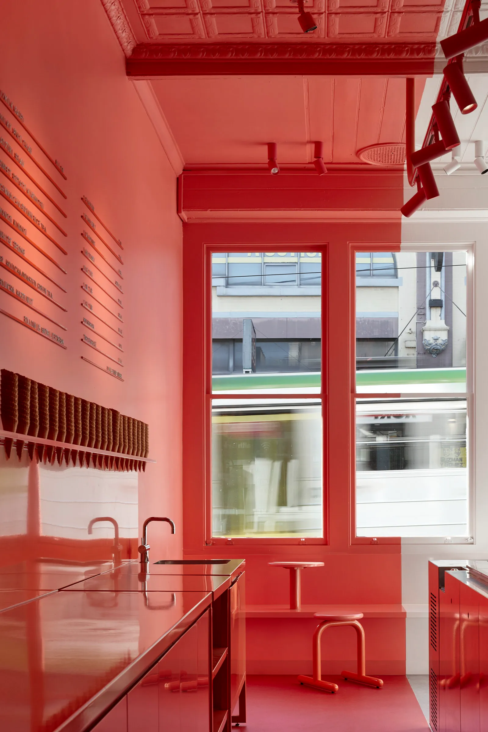 A bright red kitchen with a sink and a window, creating a warm atmosphere