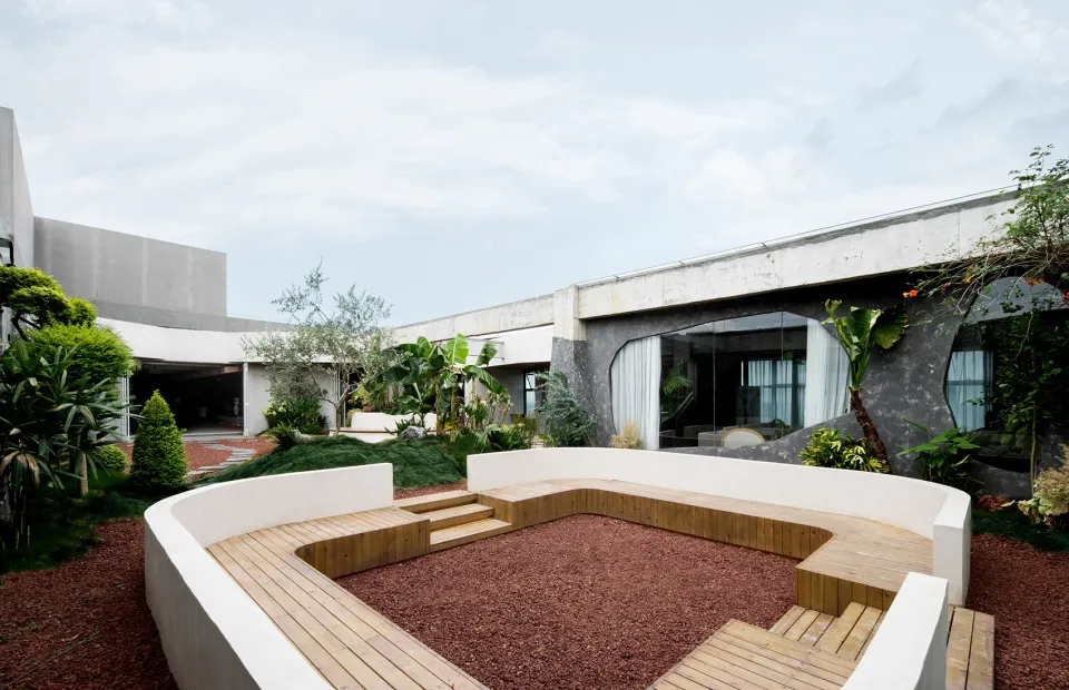 Architectural rendering of a building's exterior featuring a patio with potted plants and a bench, creating a welcoming and relaxing atmosphere