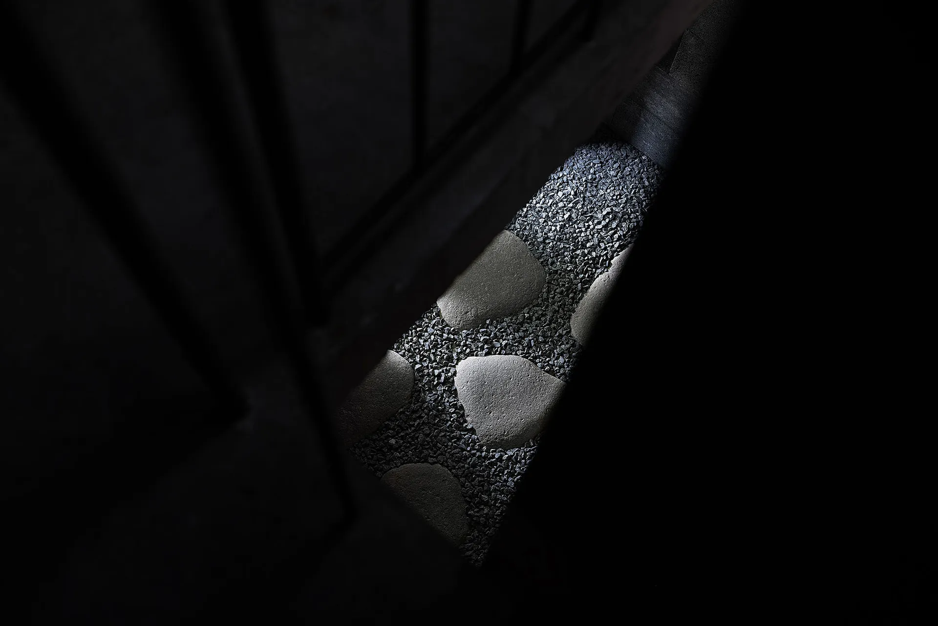 一間昏暗房間，門口地面鋪滿石塊，營造溫馨親密的氛圍