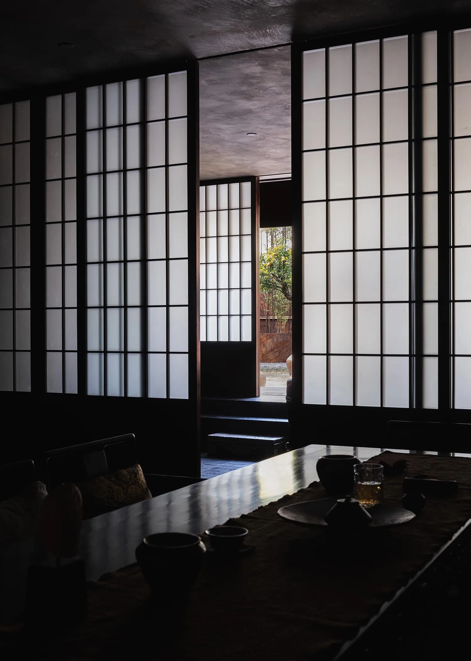 經典優雅的餐廳區，配有木桌、椅子與裝飾花瓶，背景為黑白設計