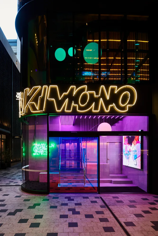 A modern interior space with neon-lit walls, a staircase, and two chairs, giving off a futuristic atmosphere