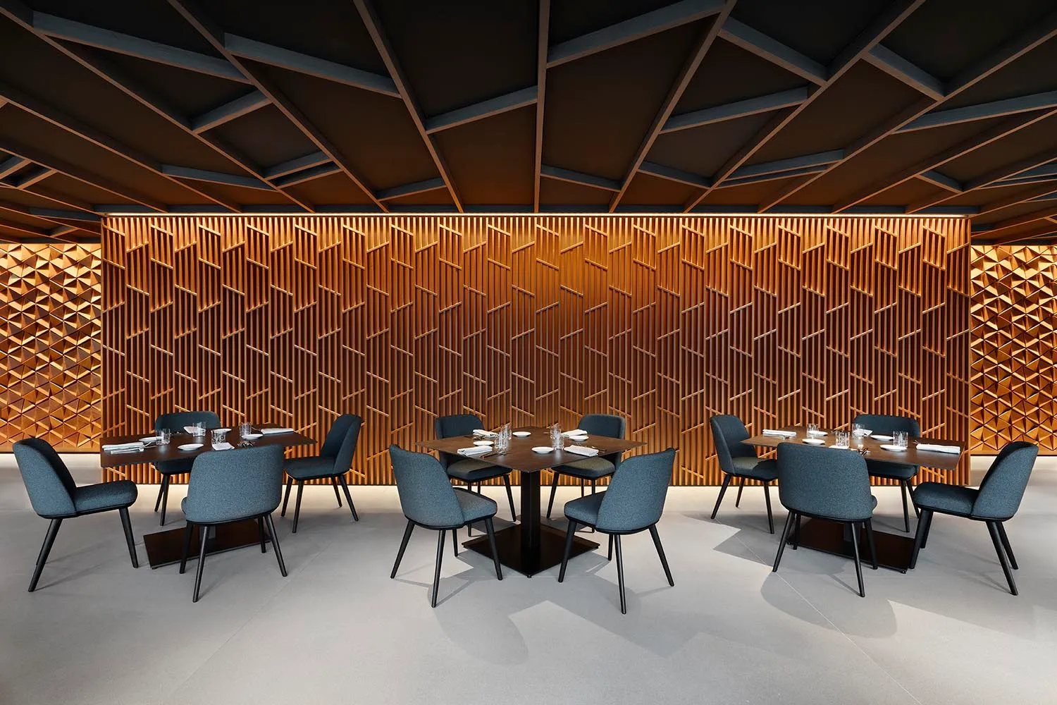 Empty restaurant with modern dining tables and chairs, wood elements, and a warm ambiance