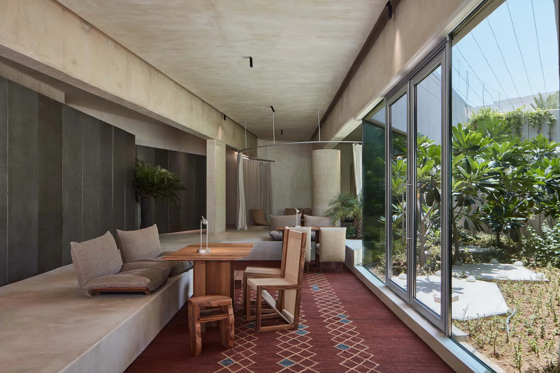 Cozy open concept living space with a red carpet, two couches, chairs, and a dining table, creating a warm and inviting atmosphere