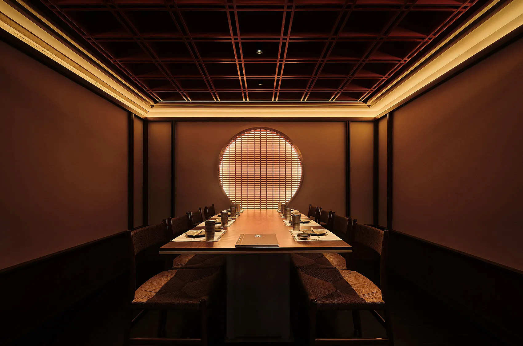 Elegant dining space with wooden walls and ceiling, featuring tables and chairs, and traditional Asian design elements