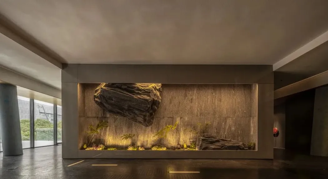 A modern living space with a large rock wall and artificially created waterfall, adding depth and interest to the environment