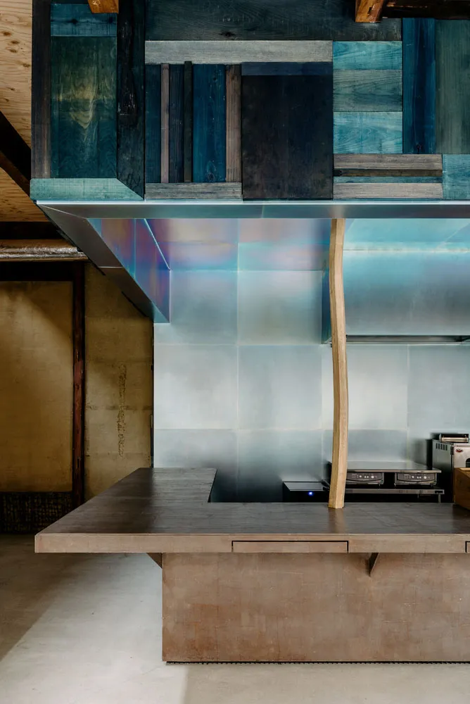 Industrial kitchen with a stainless steel island, two ovens, and three microwaves, giving off a modern and sleek vibe