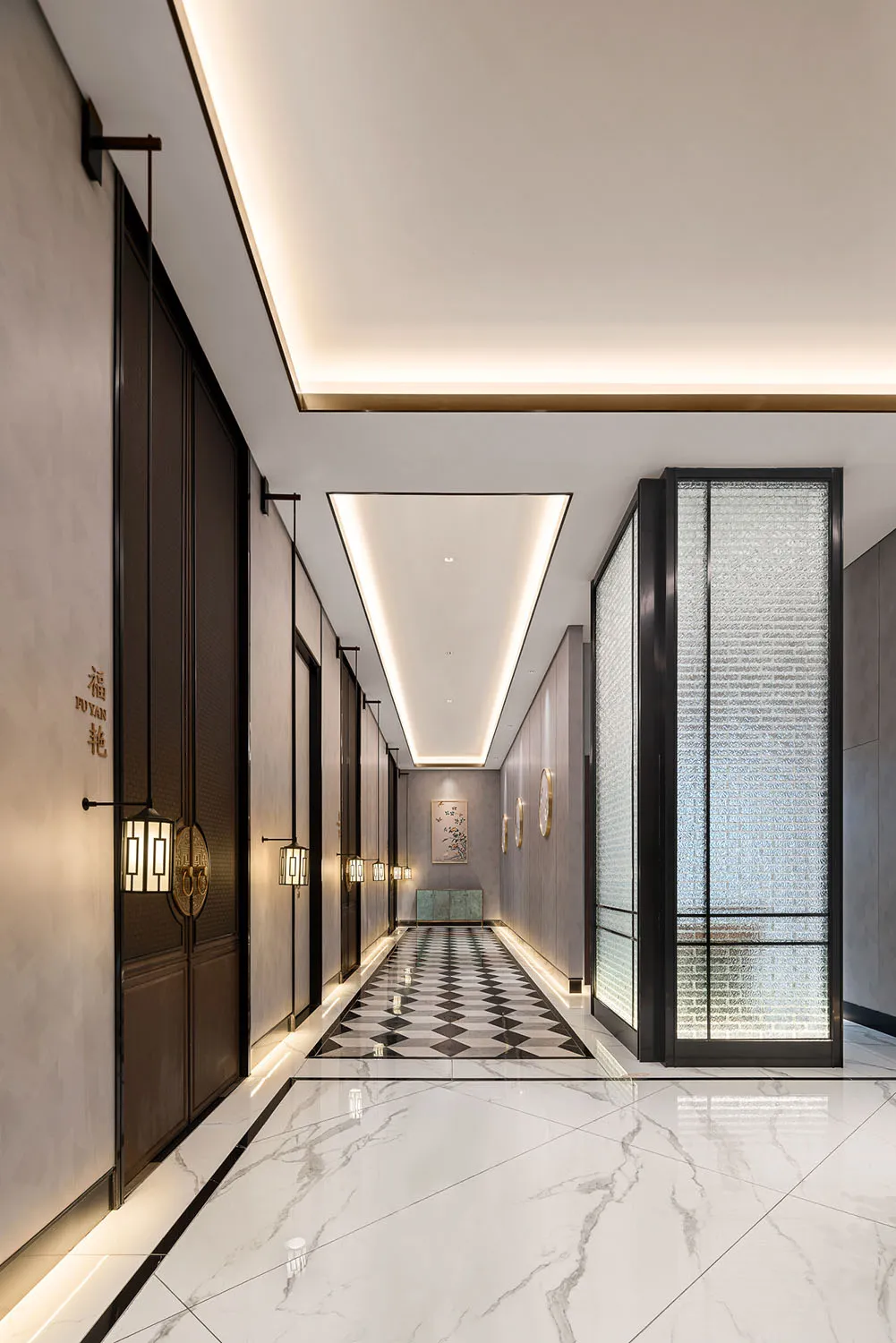 Sophisticated hallway with black and white checkered tile floor, two doors, and chandeliers providing illumination