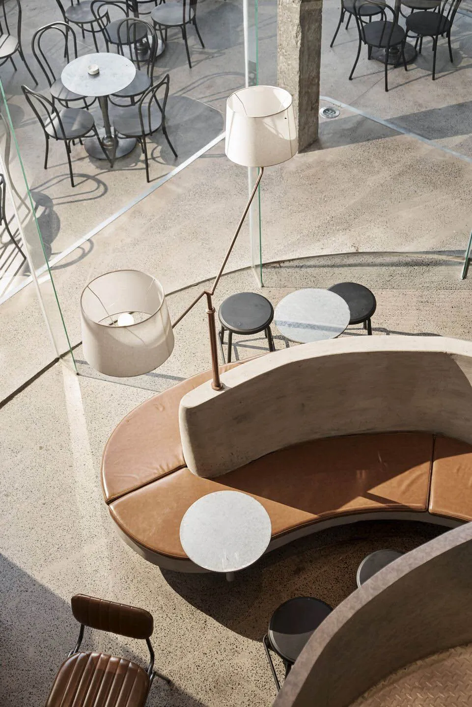 Inviting cafe with a circular seating area featuring multiple tables and chairs, creating a comfortable atmosphere for socializing and dining