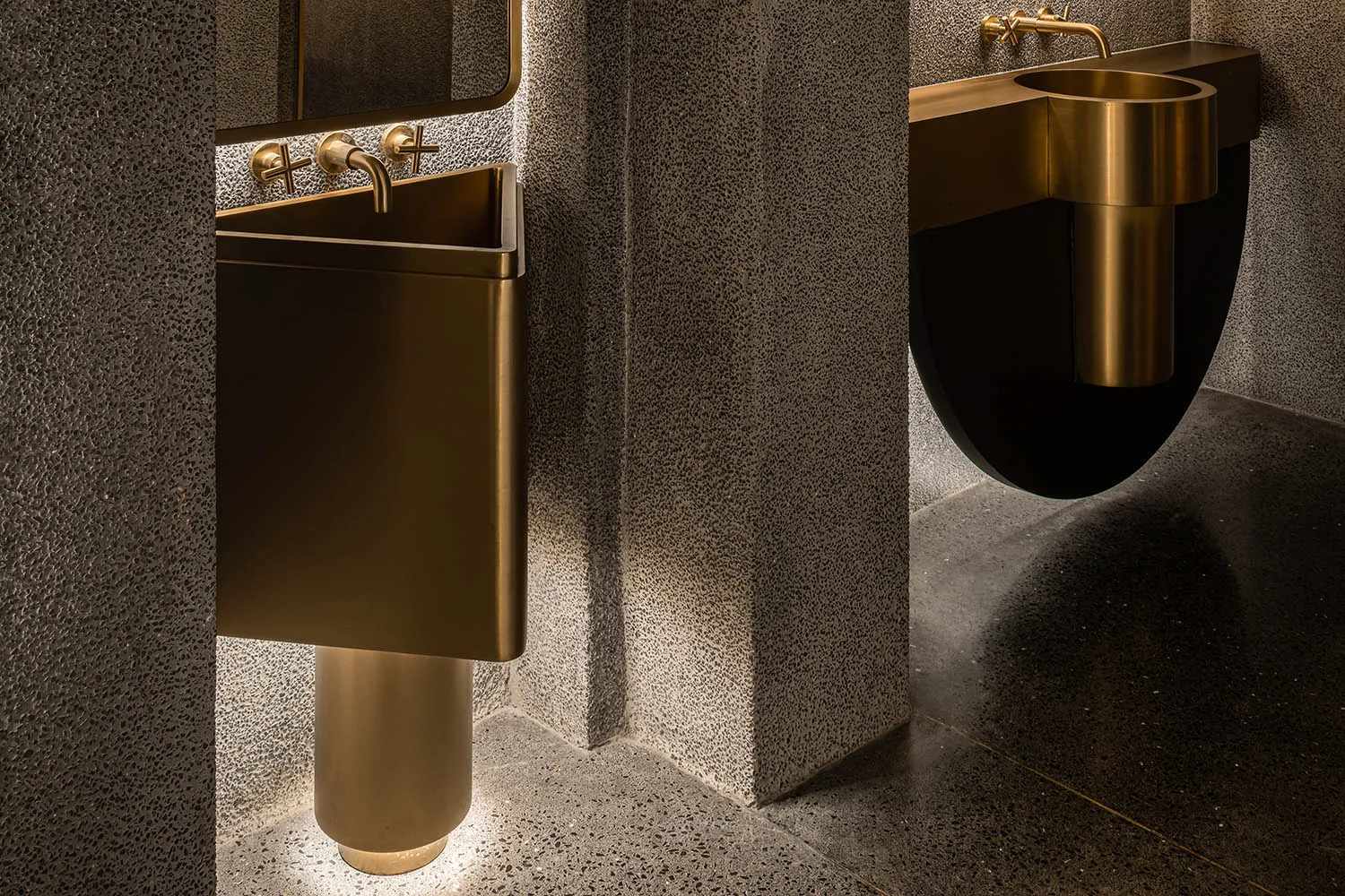 Bathroom with two gold sinks, two toilets, and an elegant design