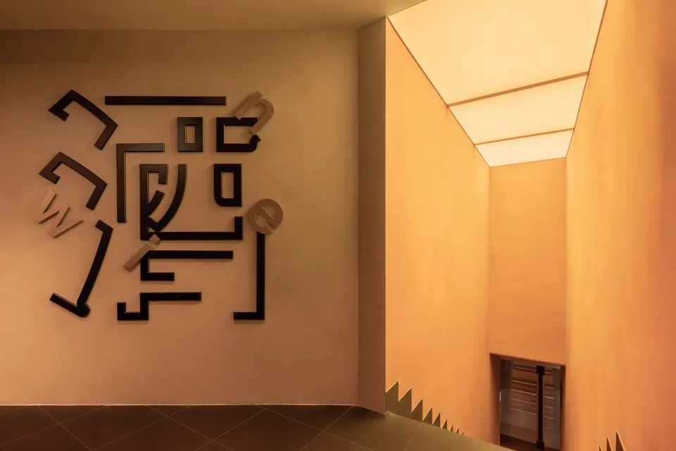 燈光昏暗的空間，獨特的拼圖牆設計，無家具或人物
