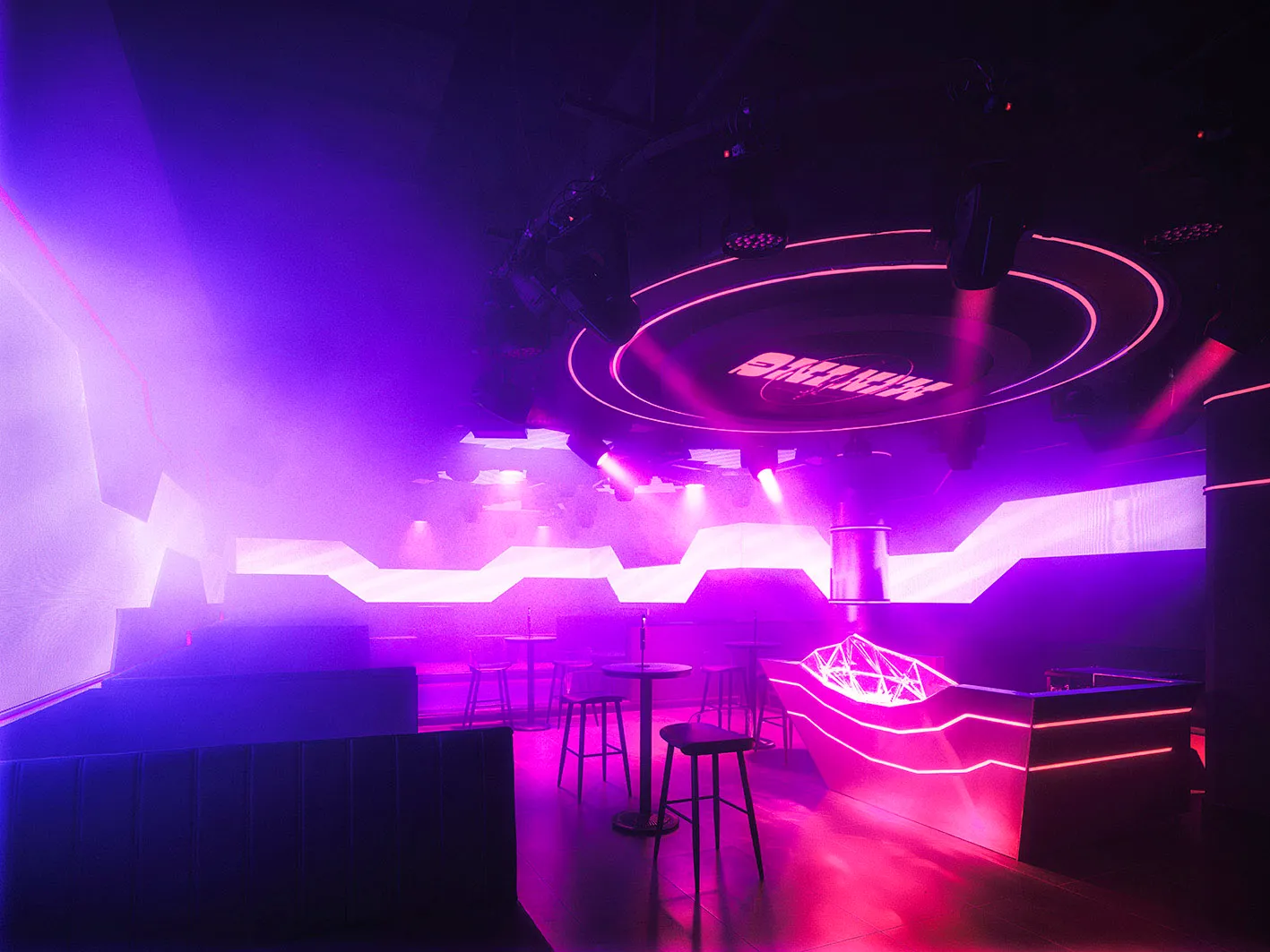 Purple-walled bar or restaurant with chairs and dining tables, inviting and comfortable atmosphere