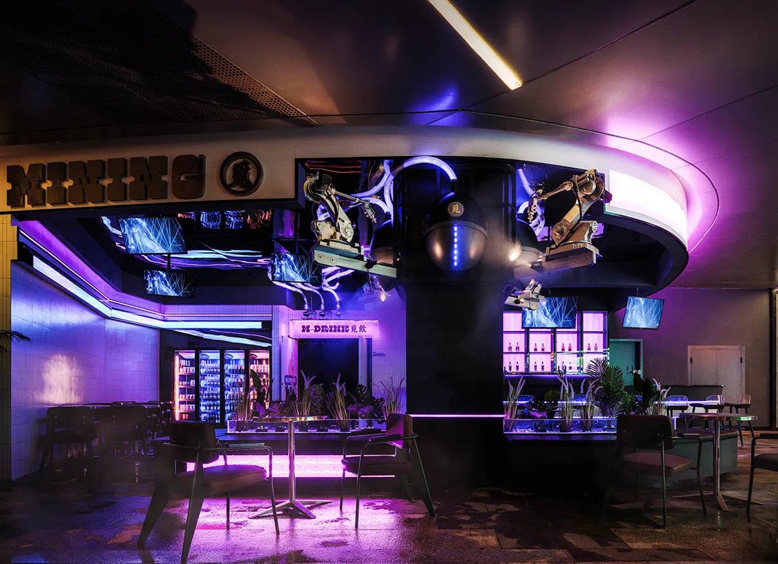 A modern bar with a purple and black color scheme, featuring a dining table and chairs, decorative elements, and bottles, creating a lively and inviting atmosphere
