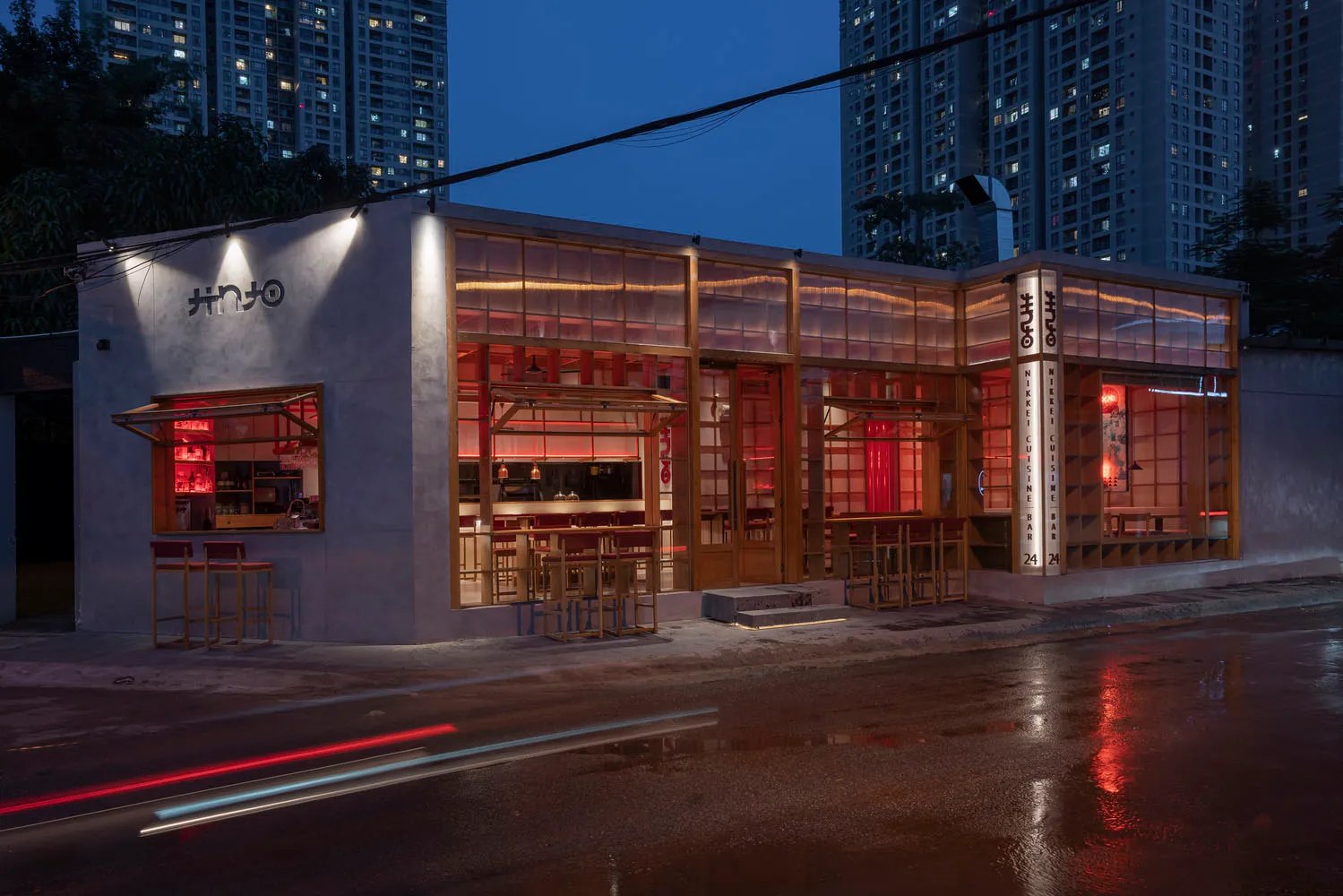 A modern Asian restaurant at night with red accents, natural light, and comfortable seating for guests