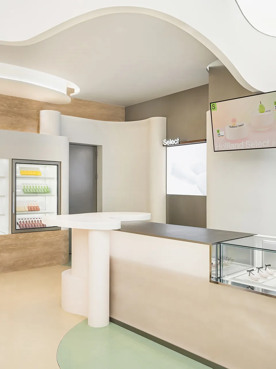 A casual cafe interior with a counter featuring a refrigerator and bottles, cups, and a welcoming atmosphere