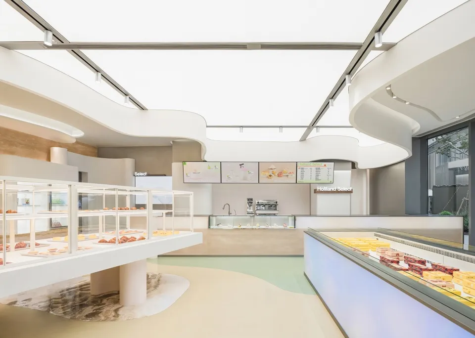 A modern restaurant kitchen and dining area with a large counter, dining table, and comfortable seating for guests