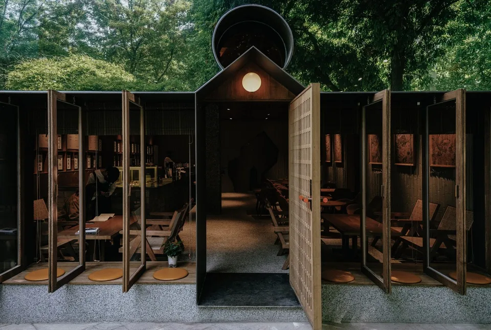 Open restaurant interior with wooden tables and chairs, wood flooring, and warm atmosphere