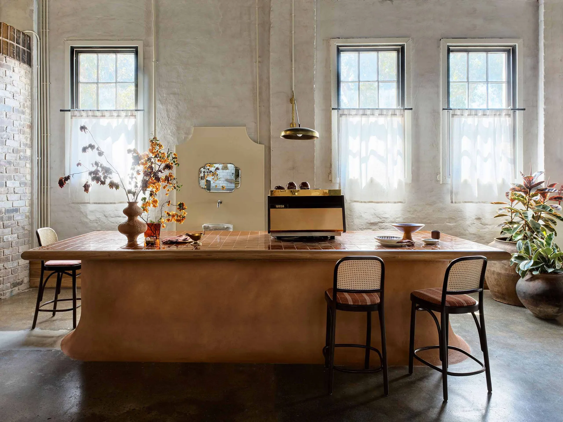 Warm and inviting kitchen with a wooden countertop, a coffee maker, two chairs, and a vase, emphasizing functionality and comfort