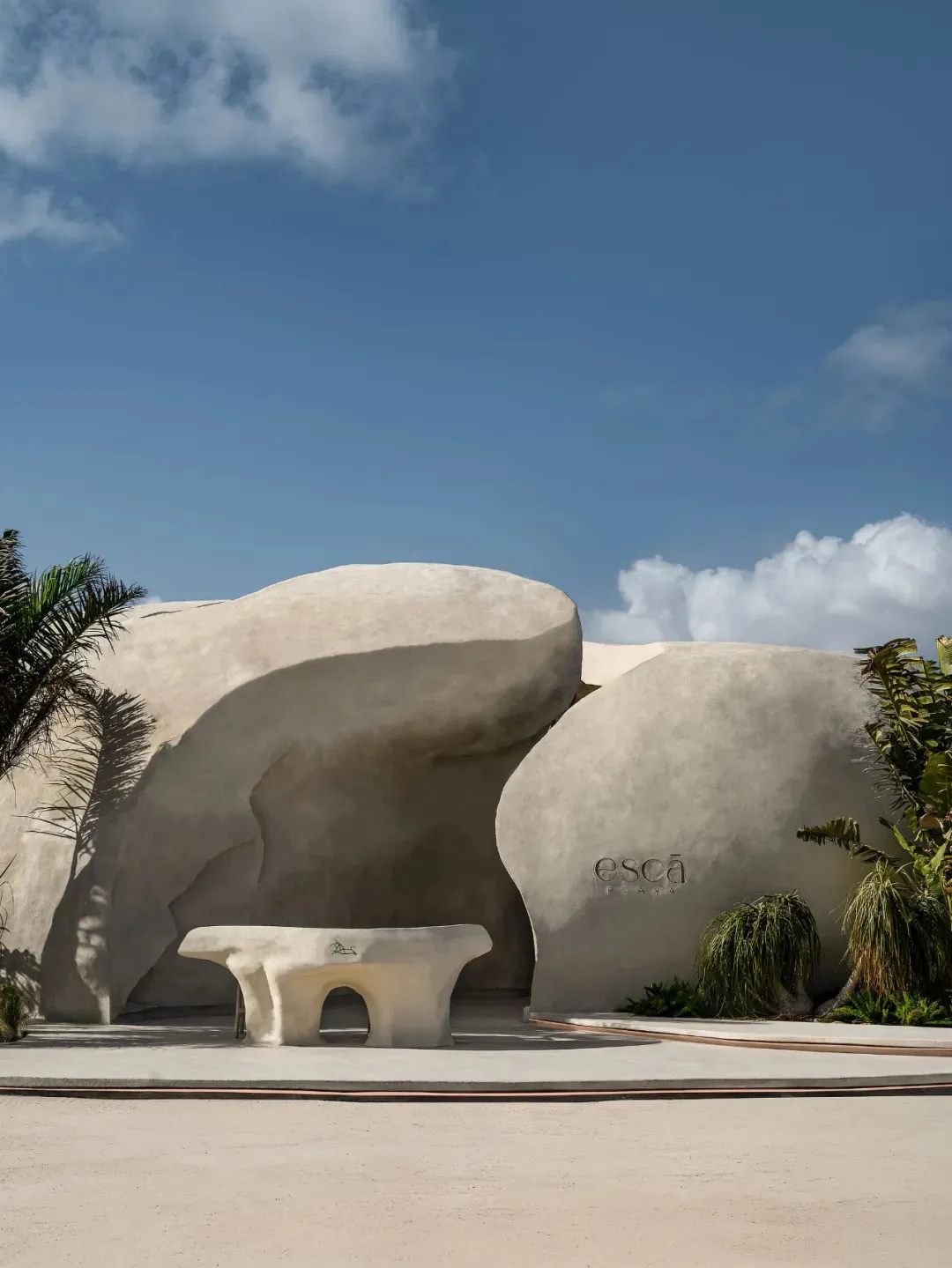 A serene landscape with a large white rock formation and a concrete bench in front, inviting visitors to sit and enjoy the view