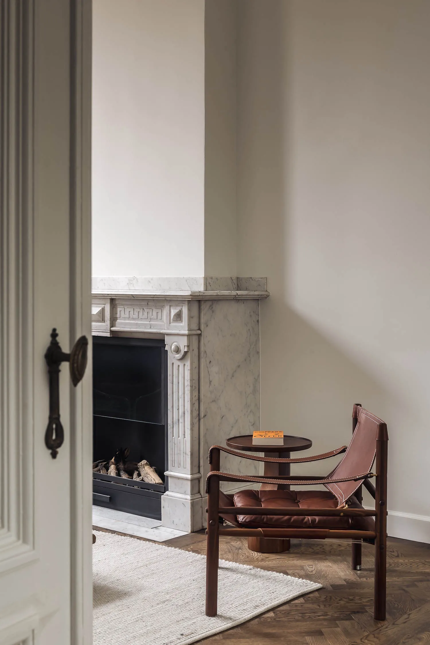 Cozy living area with a fireplace, two chairs, and a dining table, set in a warm and inviting atmosphere