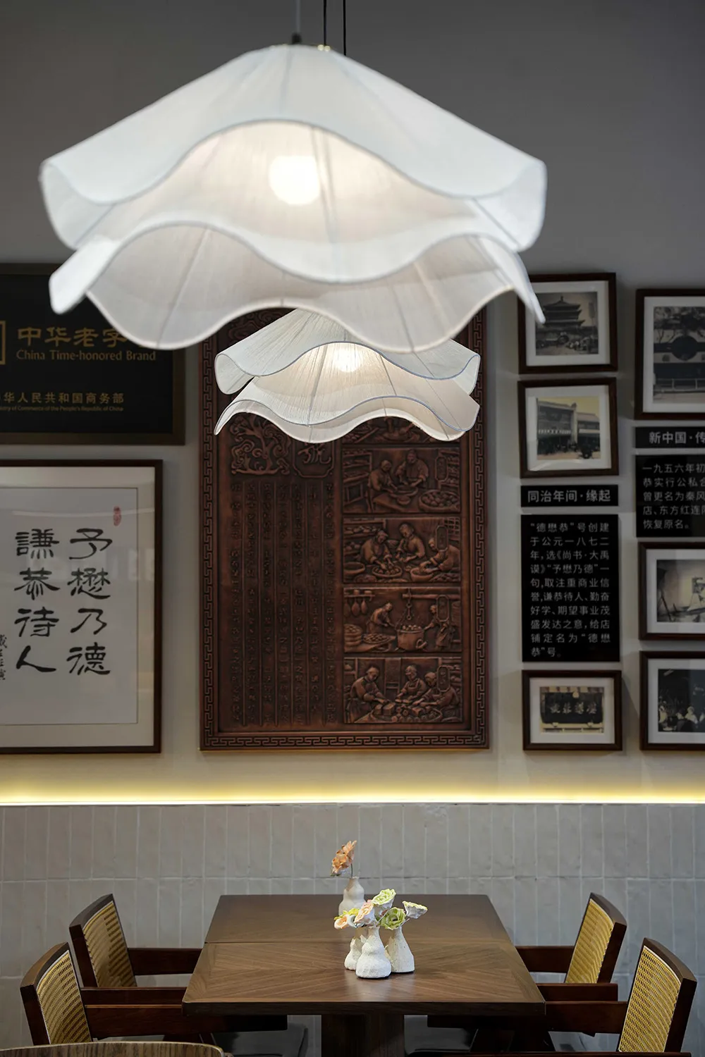 Cozy Asian restaurant interior with a wooden table, hanging lamp, and decorative elements, featuring a fusion of traditional and modern styles