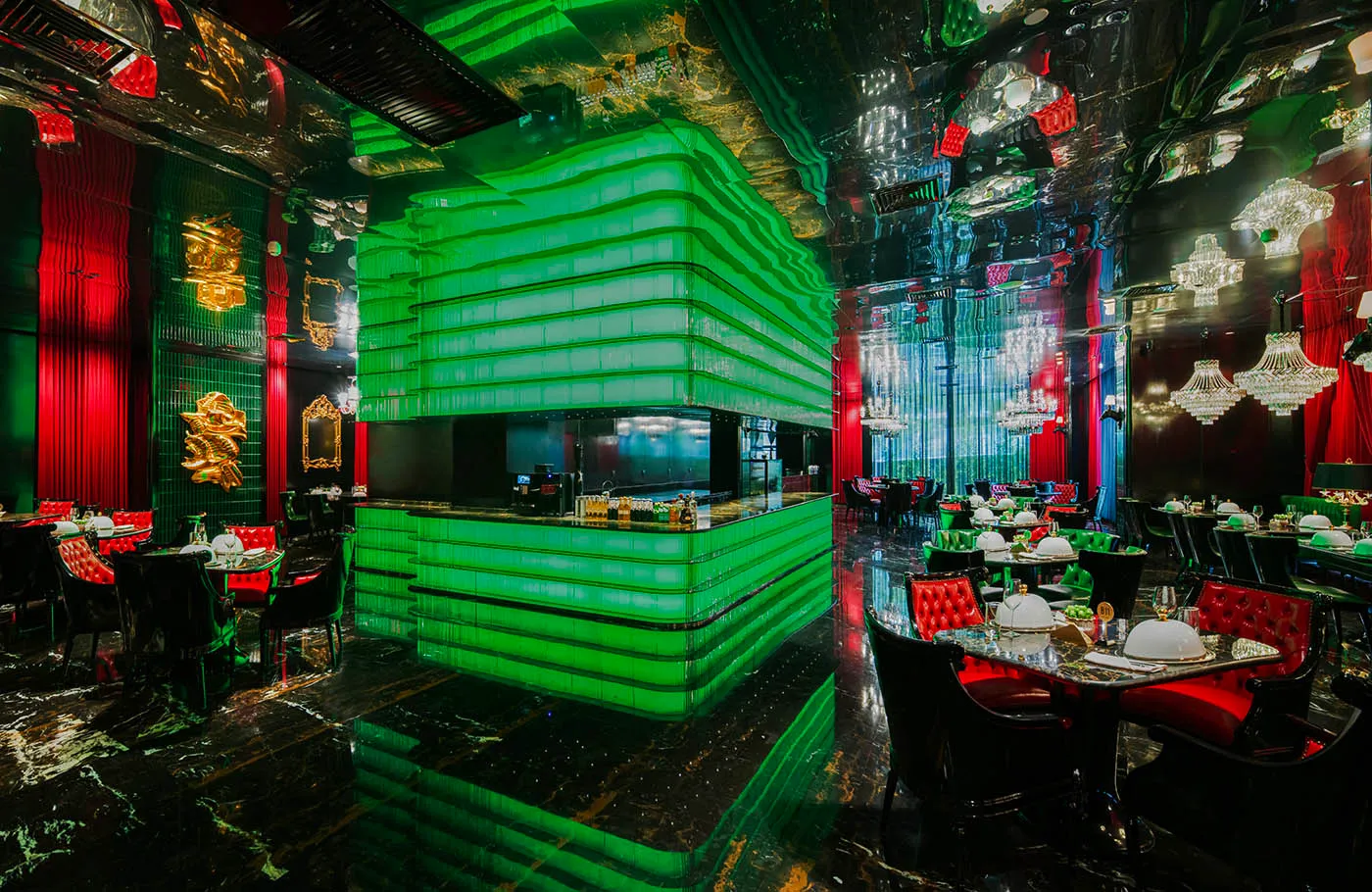 A modern restaurant with green walls and flooring, featuring a warm and inviting atmosphere created by the lighting