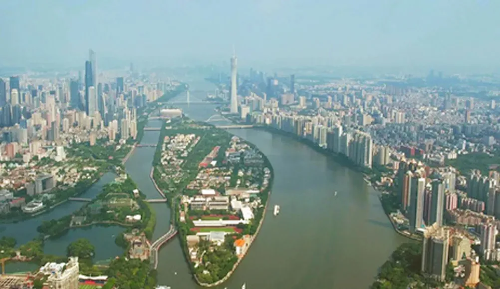 Aerial view of a bustling city with a large body of water surrounded by various buildings and boats