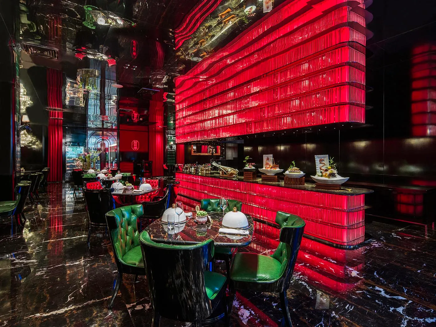 Inviting restaurant interior with red walls, green chairs, and dining tables with bowls and chairs