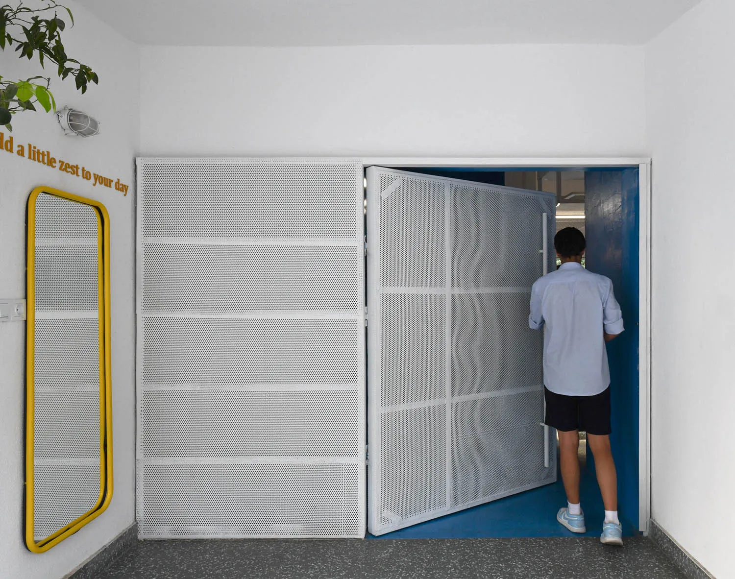 A calm and inviting hallway with a white color scheme, concrete walls, and a doorway leading into another room