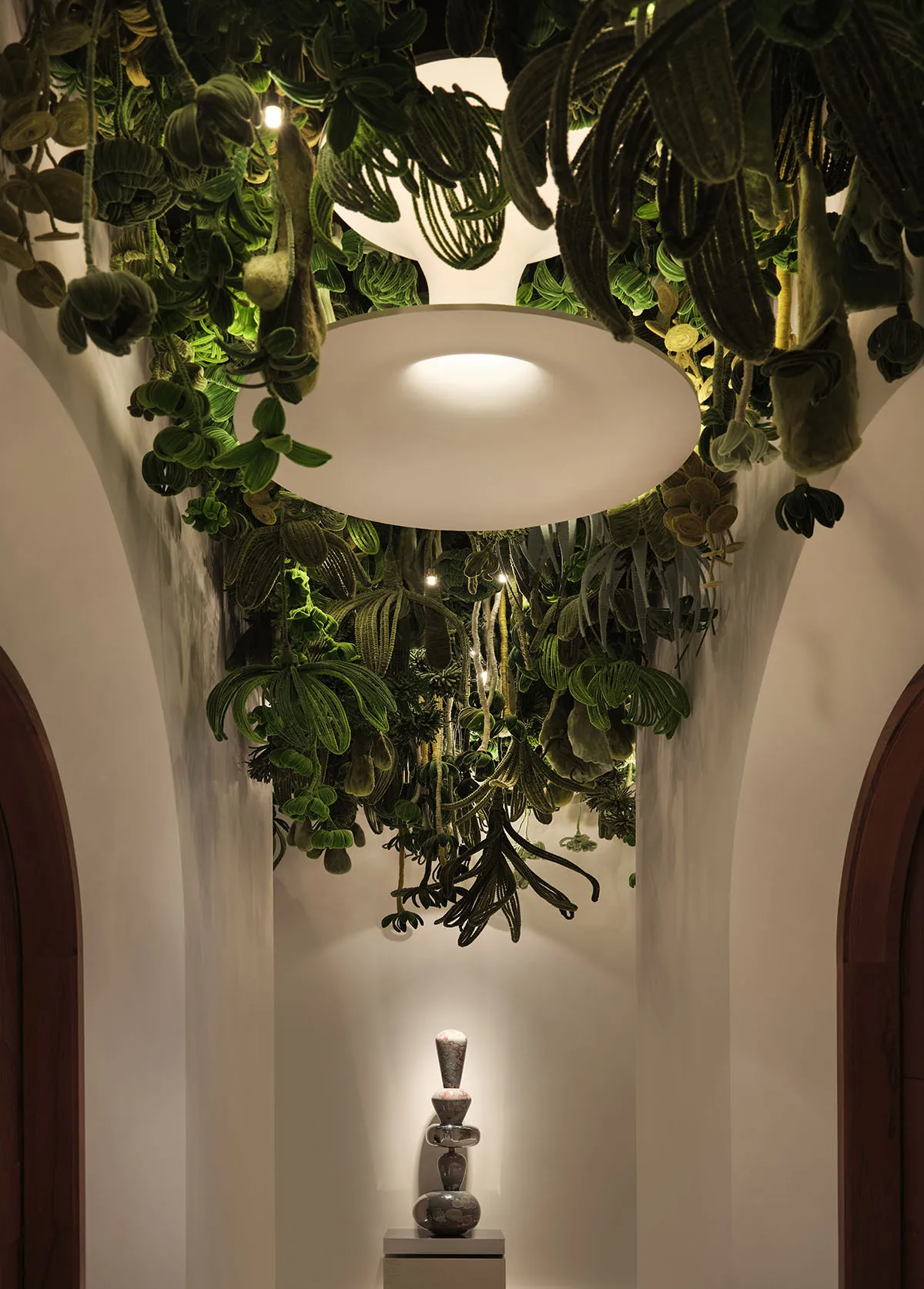 A serene indoor space with lush greenery, potted plants, and a vase, set against a white background