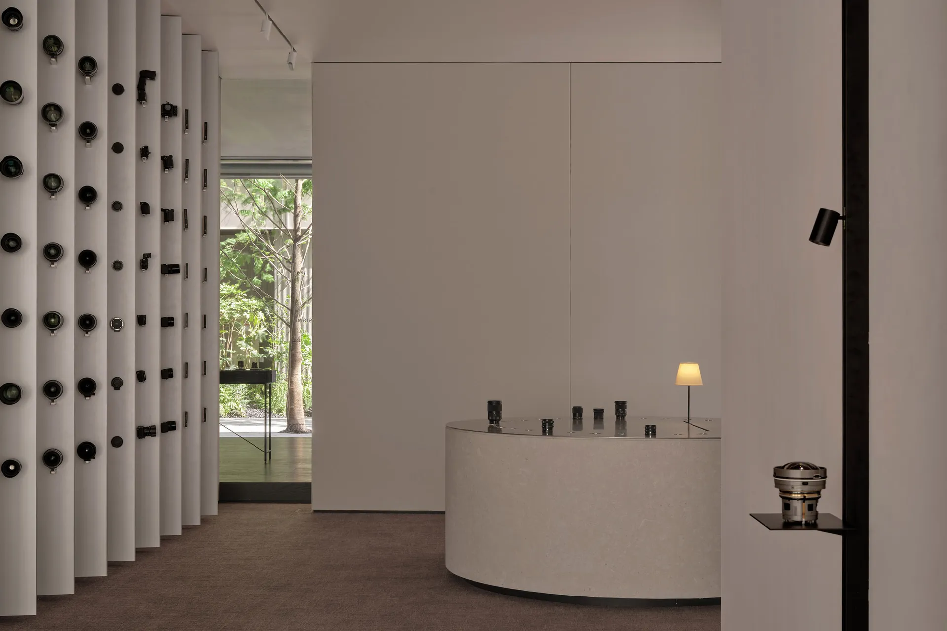 Empty room with white walls and floors, featuring small tables and lamps in a minimalist and clean atmosphere