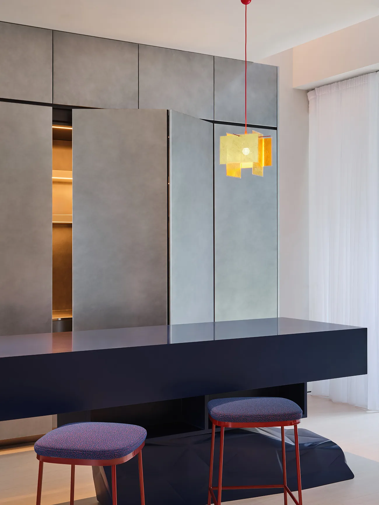 Sleek modern kitchen with grey walls and cabinets, a dining table, and two chairs, surrounded by contemporary design elements