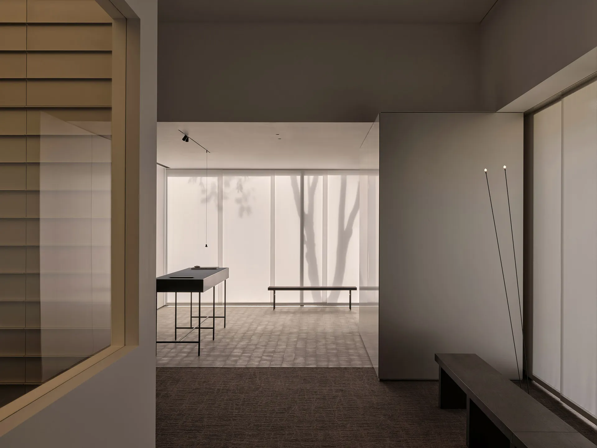 A calm and inviting lobby with two benches, a large window, and natural light