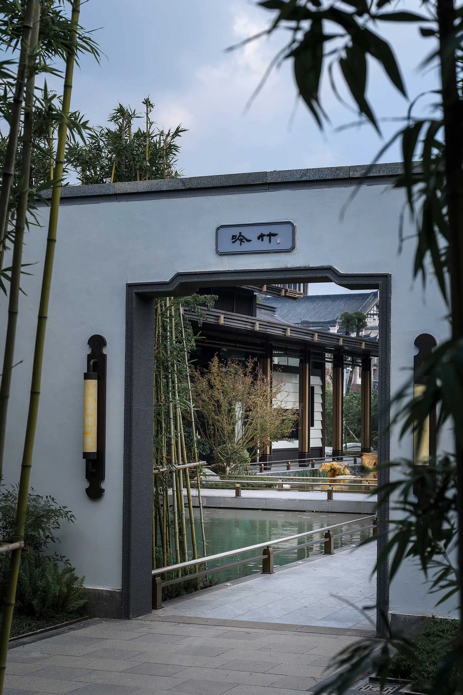 Traditional Asian-style building with a large entrance featuring bamboo elements, surrounded by natural materials and serene atmosphere