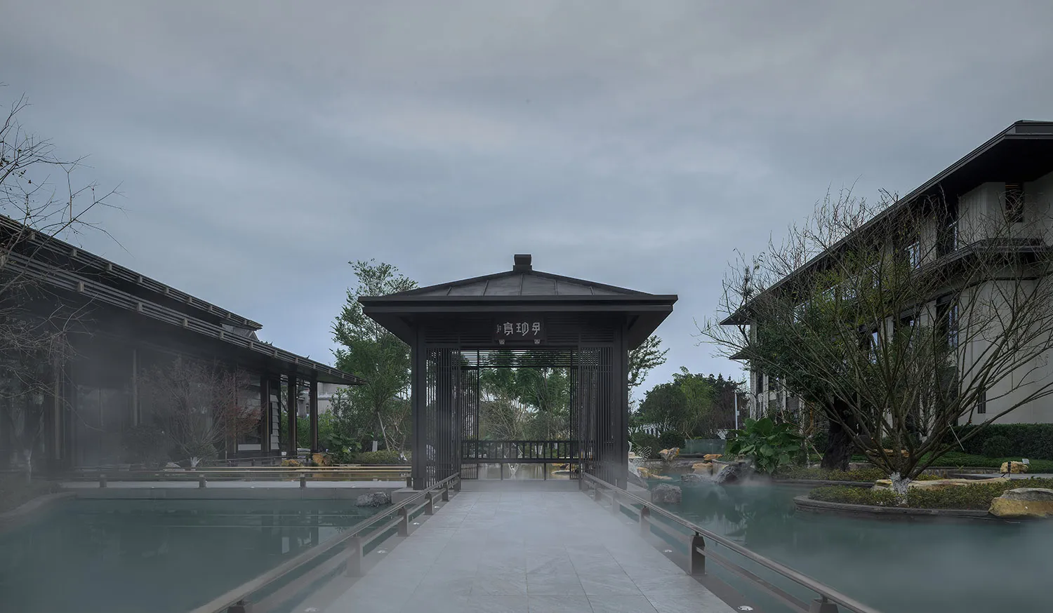 Asian-style building with a bridge leading to its entrance, surrounded by water, featuring a mix of traditional and modern elements