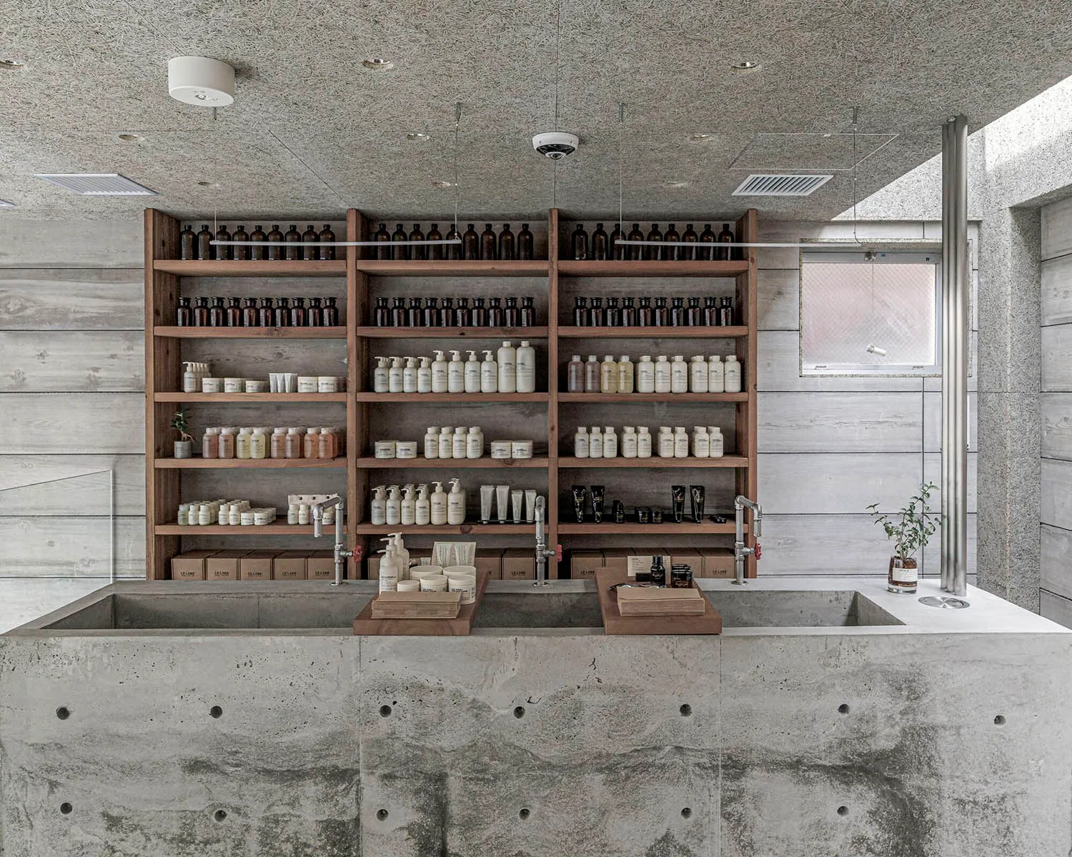 Bathroom with a sink and multiple shelves displaying various bottles of soap, creating a clean and organized atmosphere