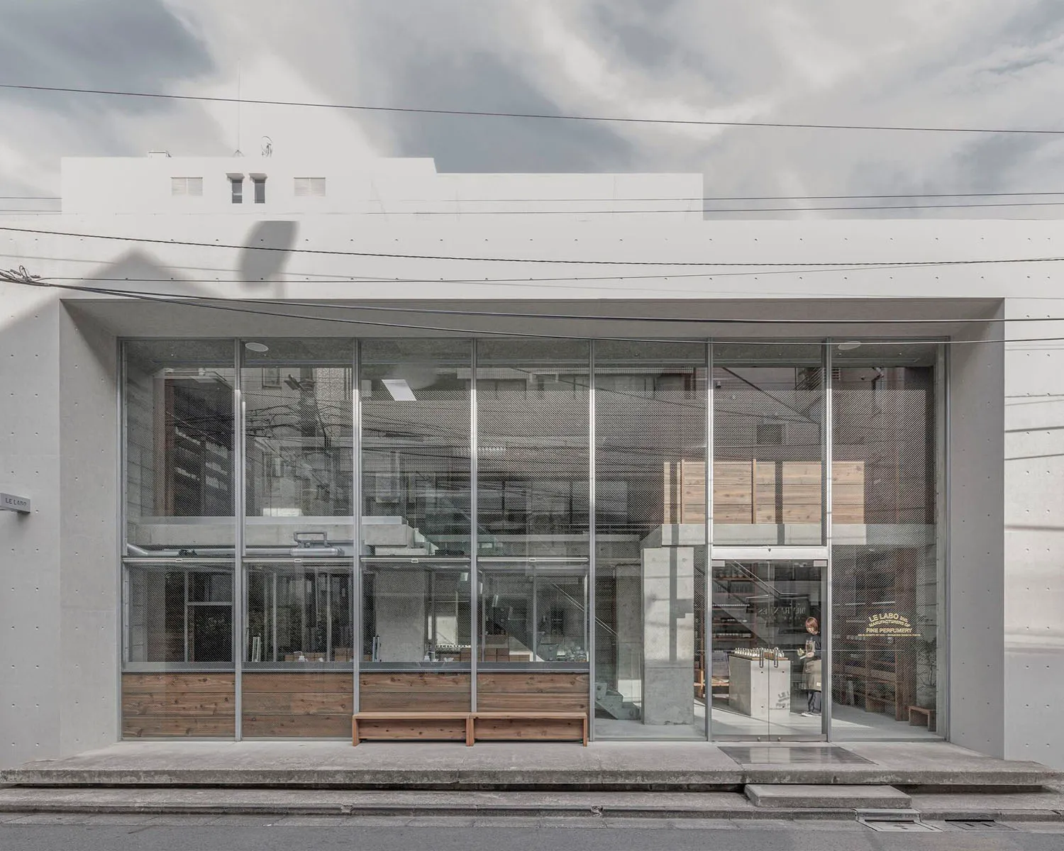 A modern building with large glass walls and natural light, featuring outdoor seating areas and a contemporary atmosphere