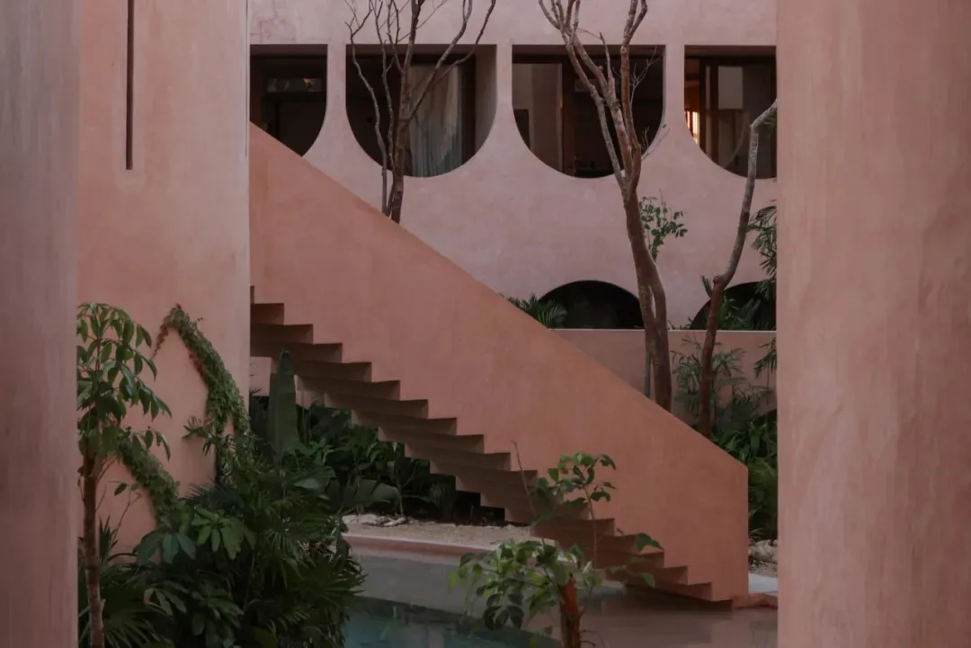 A house with a wooden staircase and a calm atmosphere, surrounded by two trees