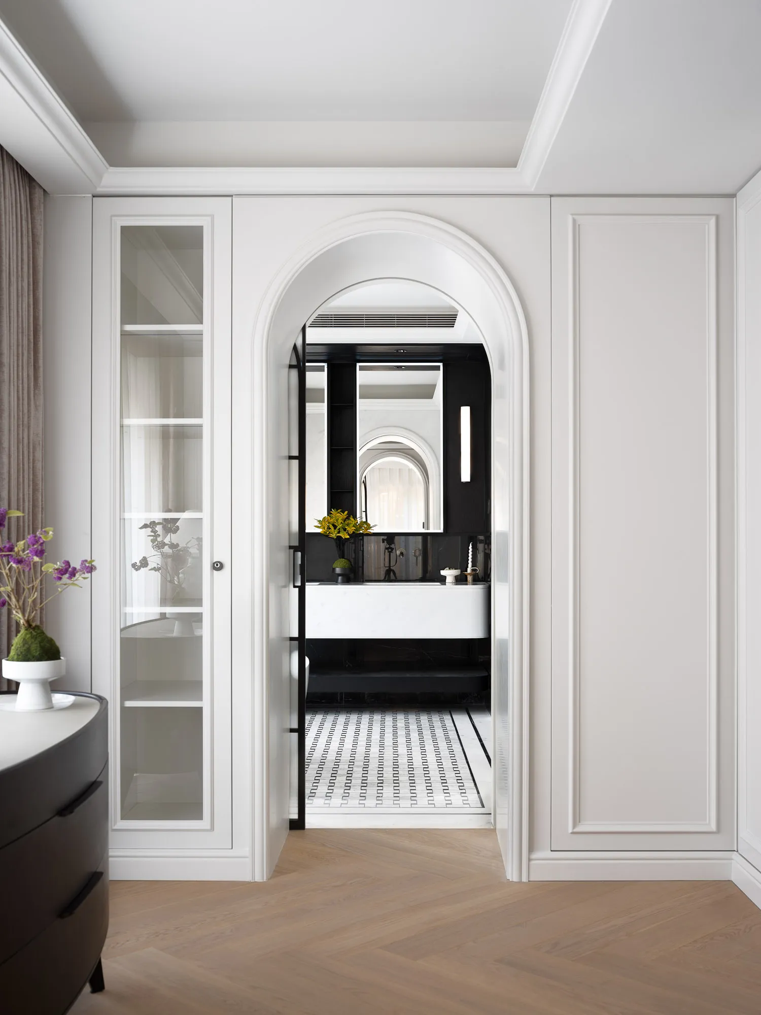Sophisticated bathroom with a large mirror above a sink, vases, and a potted plant adding a touch of greenery