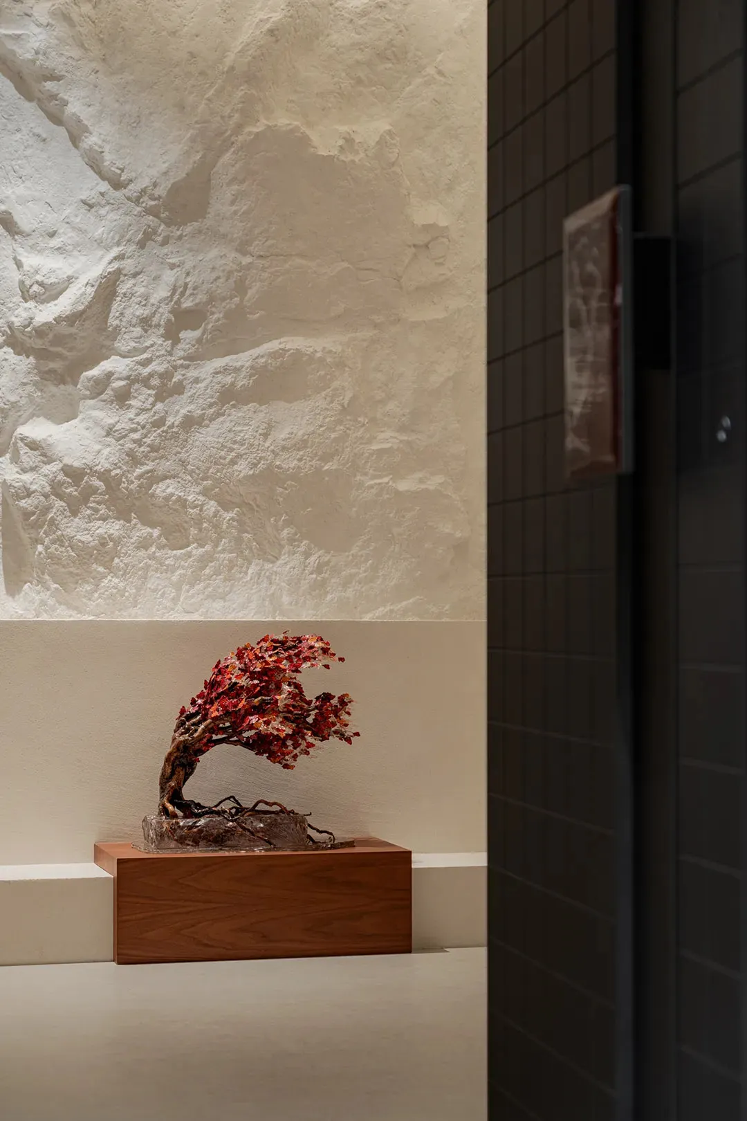 A wooden table with a tree sculpture on display in a calm and inviting indoor space