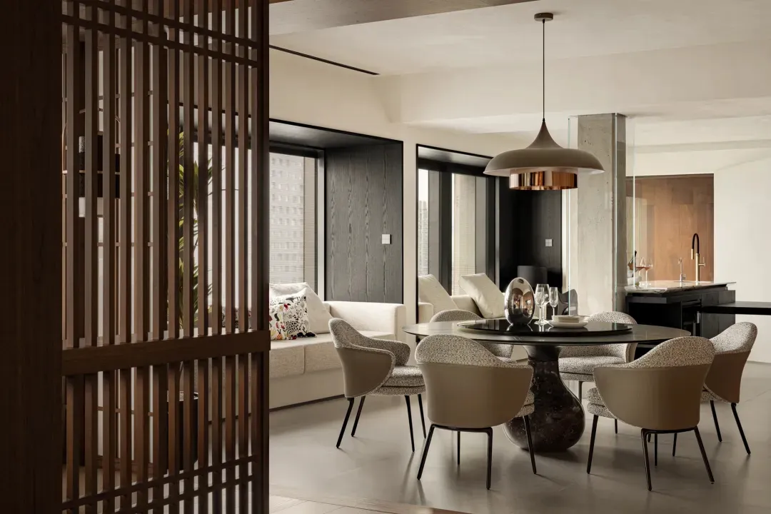 Elegant open concept dining area with a wooden dining table and chairs, wine glasses, and a warm atmosphere