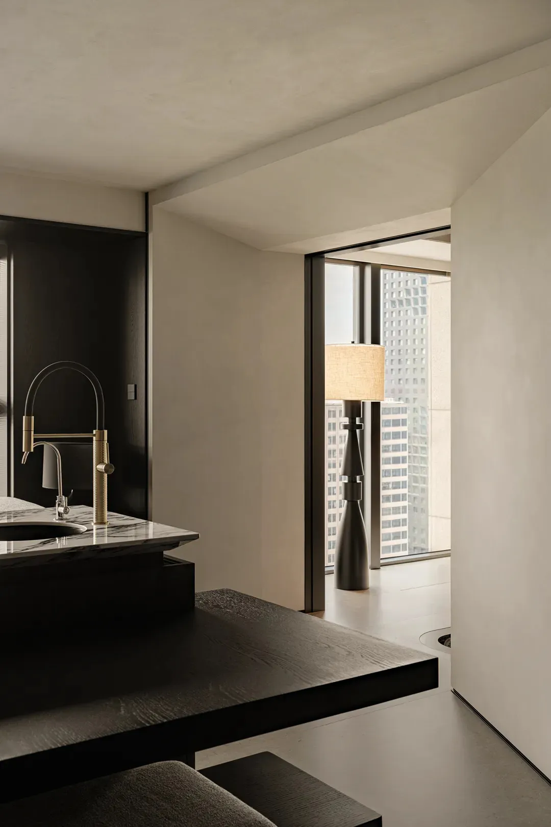 Modern bathroom with a sink, mirror, and window, featuring clean lines and minimalistic elements, with natural light and two bottles