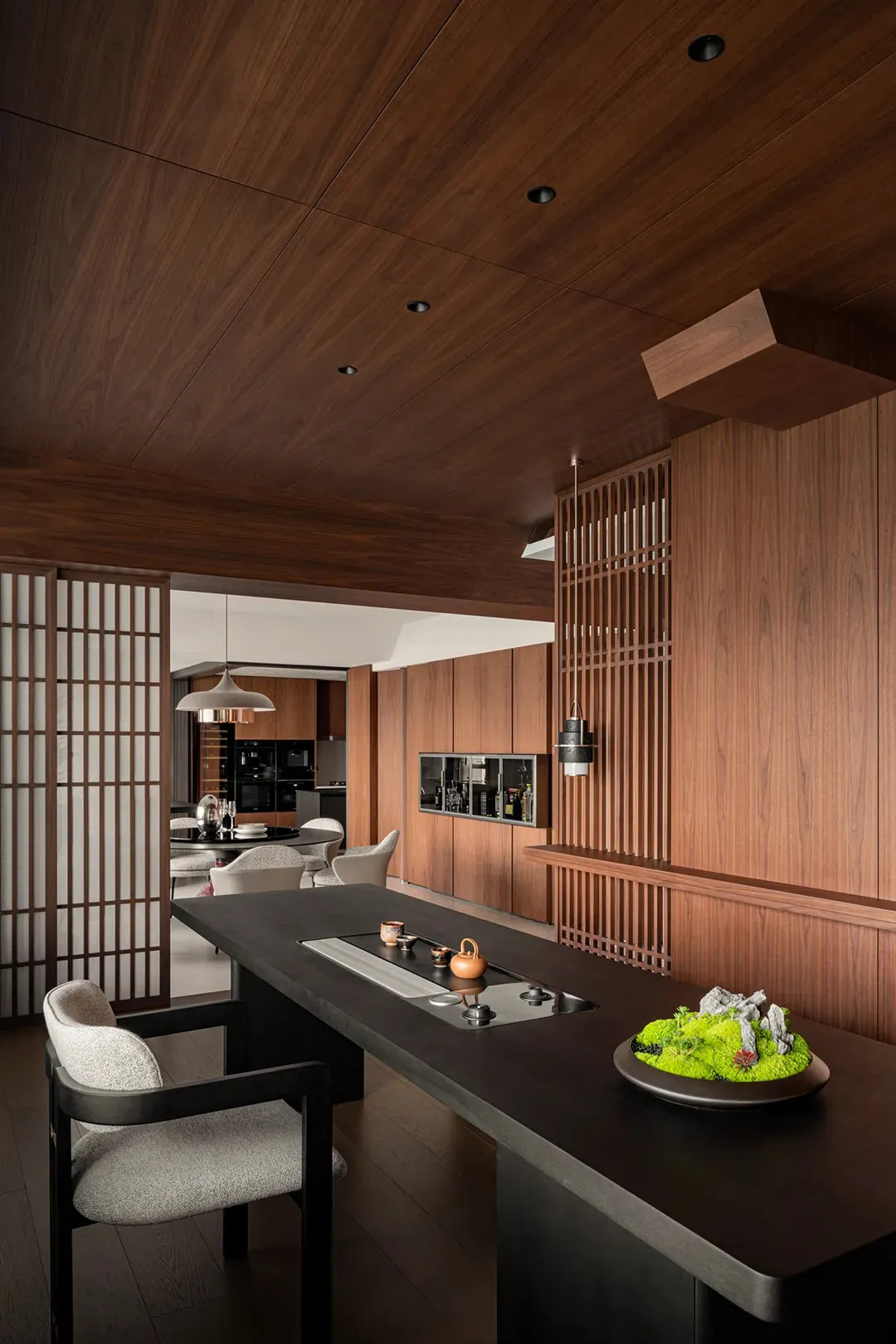 A modern kitchen and dining area with wooden walls and floors, featuring a dining table and chairs, and a sink near one of the walls