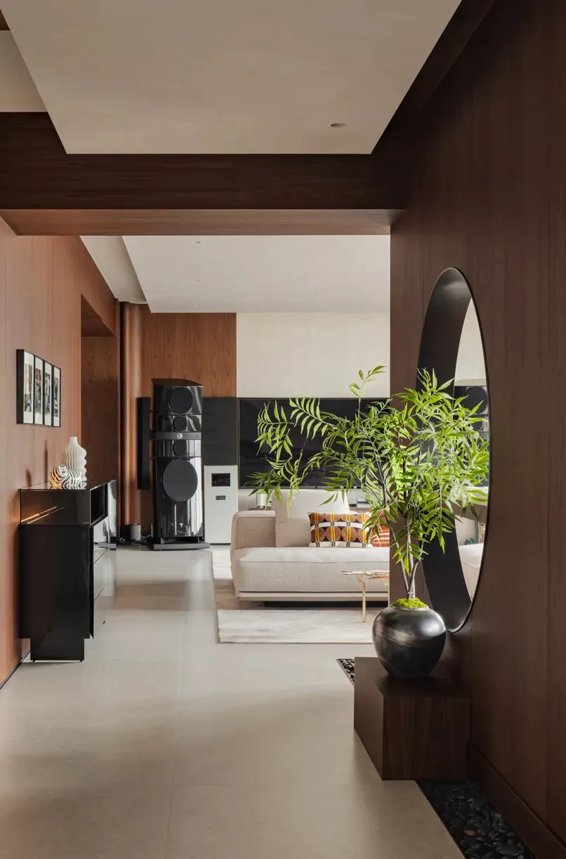 Open concept living and dining area with modern furniture, a TV, and a potted plant, surrounded by well-lit walls and a dining table with chairs