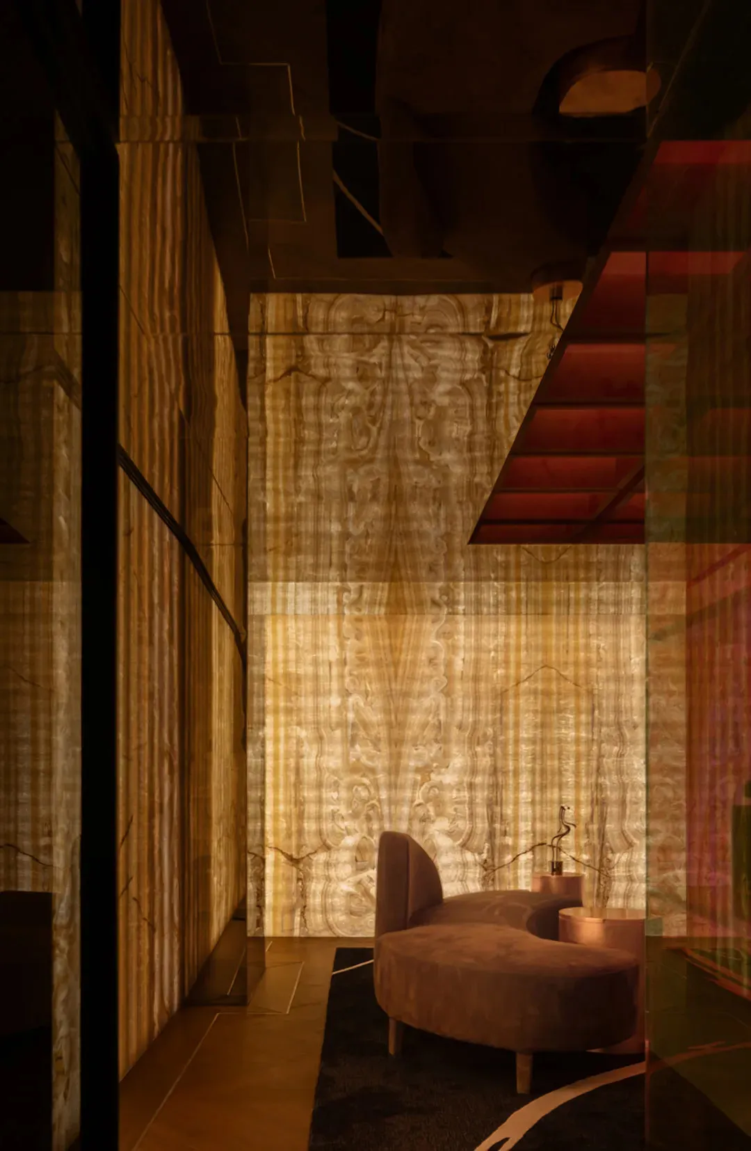 Cozy living area with a couch and two chairs, dimly lit with wood and stone wall features