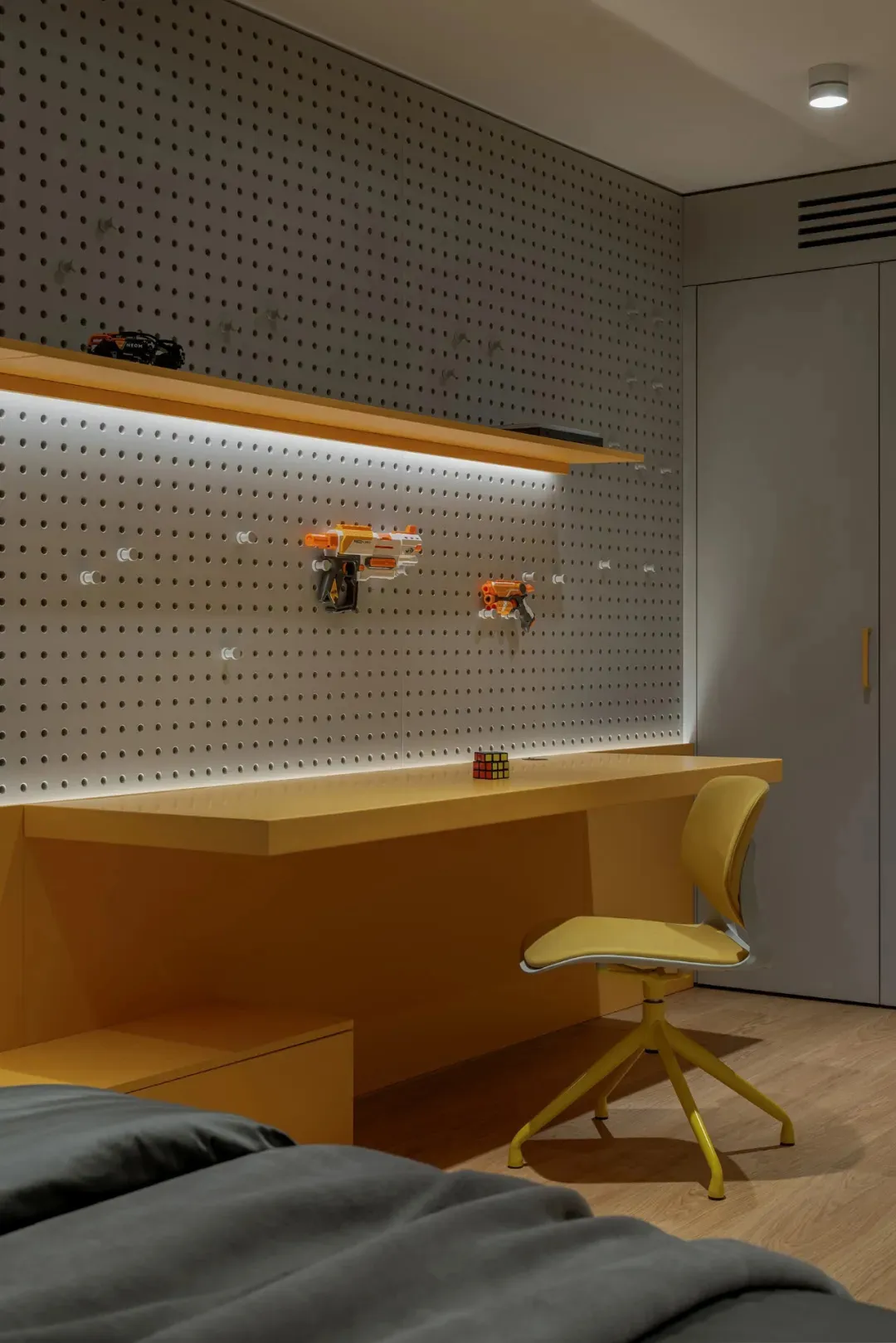 A well-lit room with a yellow desk, two chairs, and a playful atmosphere