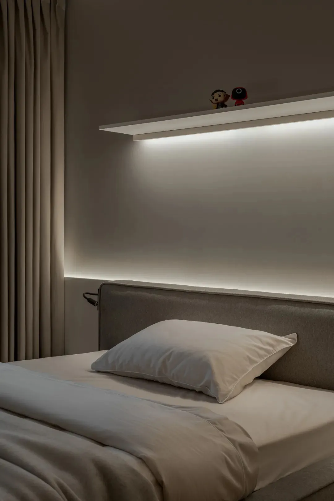 Cozy bedroom with a large white bed, wooden headboard, and two small figurines on the bed