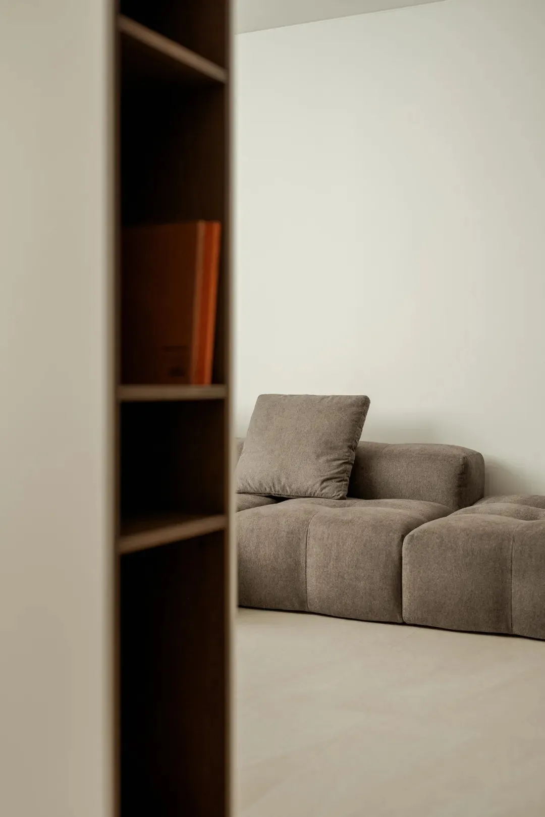 Cozy living area with a grey couch on a hardwood floor, featuring two books and a warm atmosphere