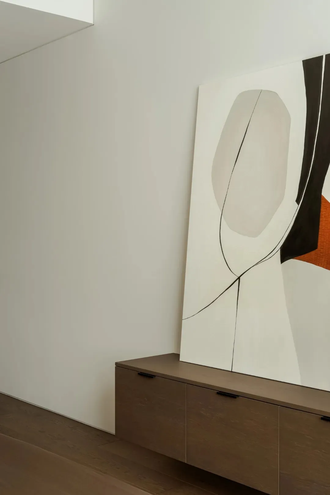 A calm and inviting room with a large abstract art piece on display, set against a wooden-framed wall