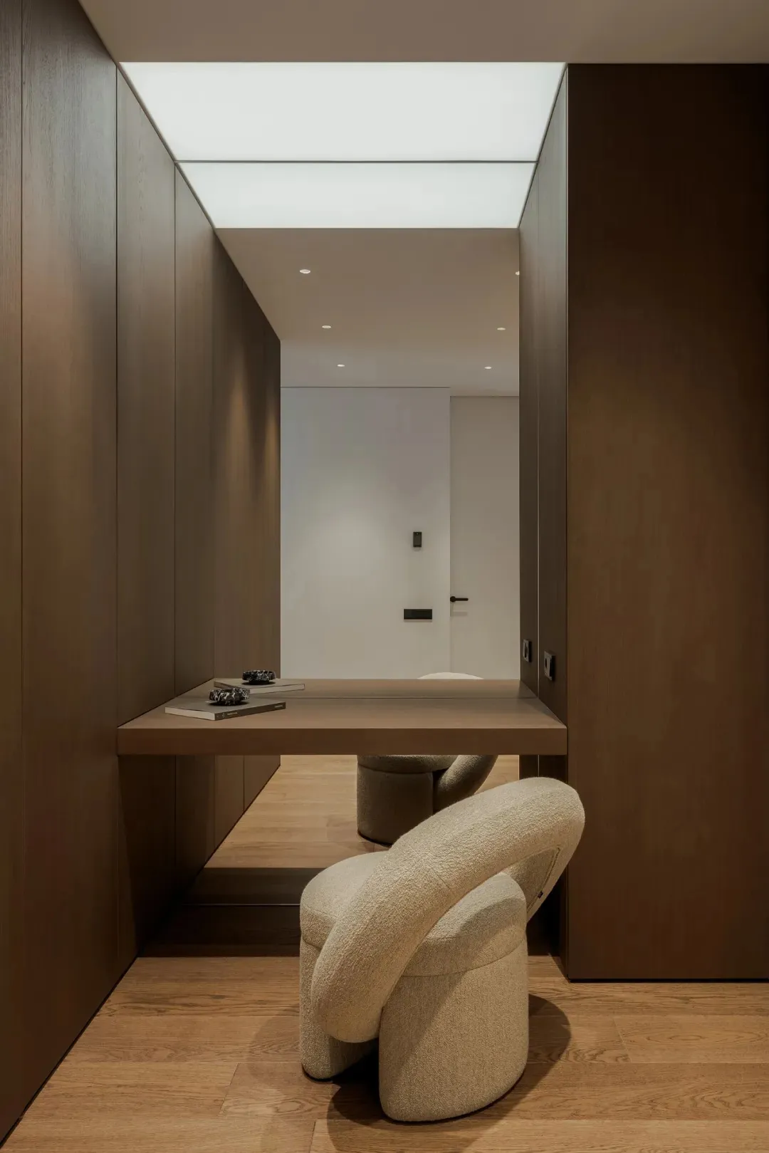 Cozy modern living space with brown wood furniture, white cushions, and a dining table, creating a warm and inviting atmosphere