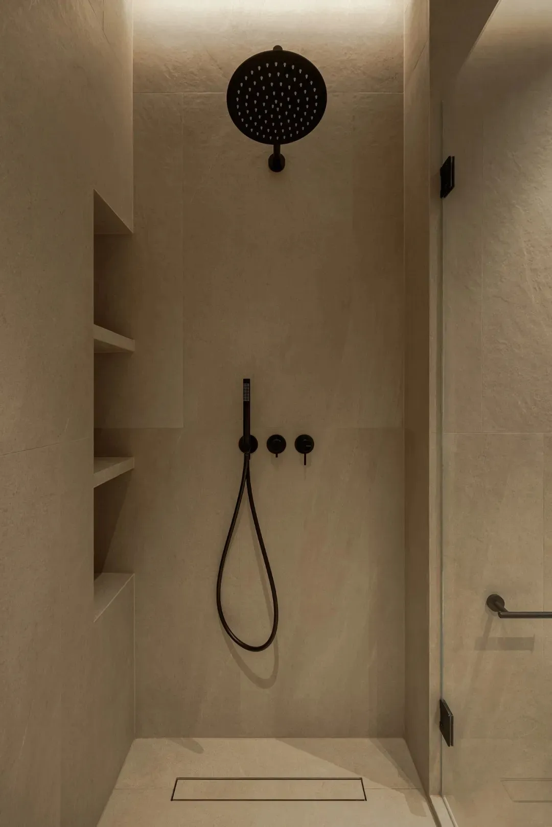 A modern bathroom with a white bathtub and two shower heads, set against a backdrop of tile-walled surfaces